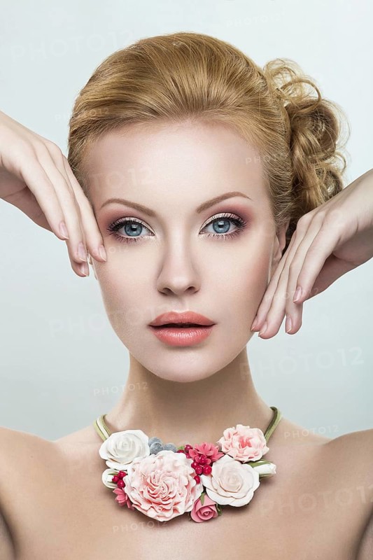 Portrait of a beautiful girl with pink flowers on her head. Photo shot in the Studio on a white background