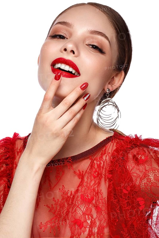 Beautiful girl in red dress with classic make-up and red manicure. Beauty face. Photo taken in the studio