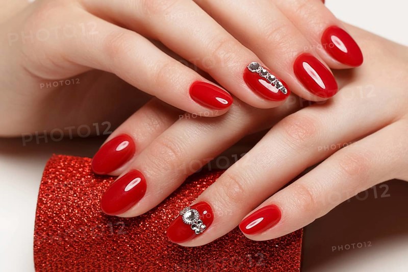 Bright festive red manicure on female hands. Nails design