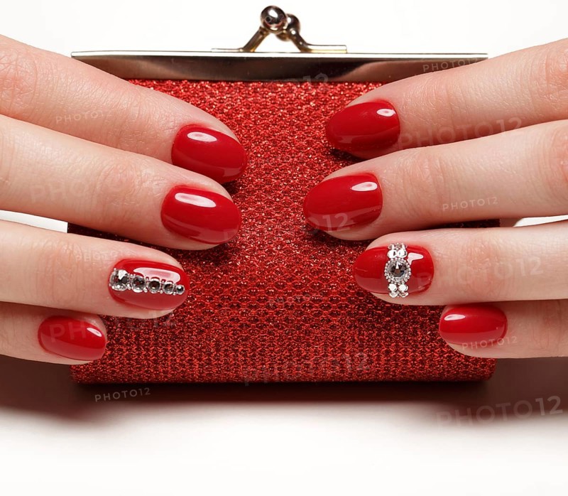 Bright festive red manicure on female hands. Nails design