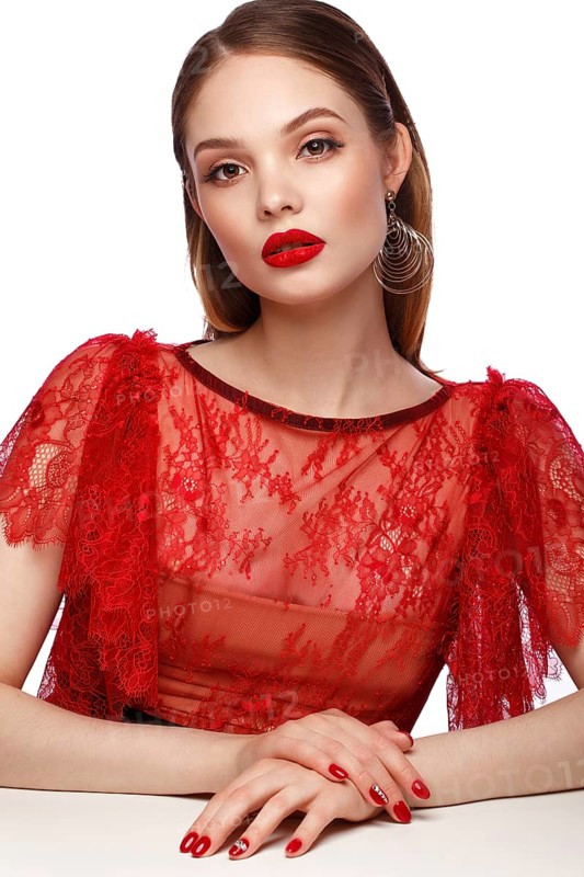 Beautiful girl in red dress with classic make-up and red manicure. Beauty face. Photo taken in the studio