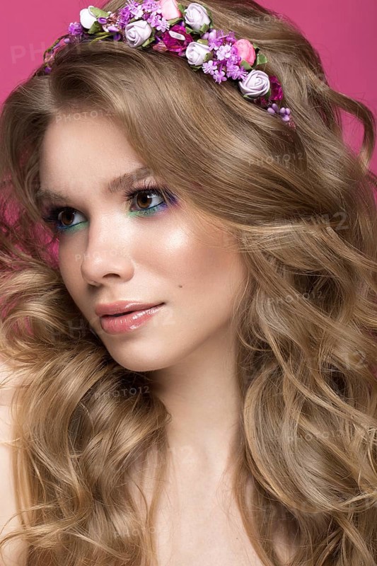 Portrait of a beautiful blond girl in image of the bride with purple flowers on her head. Beauty face. Photo shot in the Studio