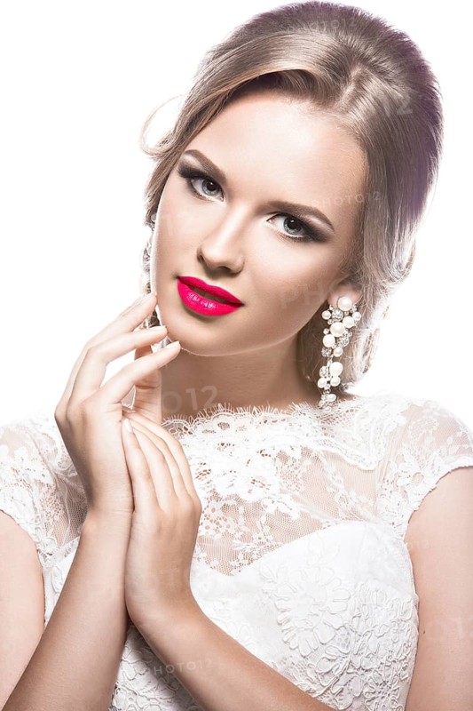 Portrait of a beautiful woman in a wedding dress in the image of the bride. Picture taken in the studio on a white background