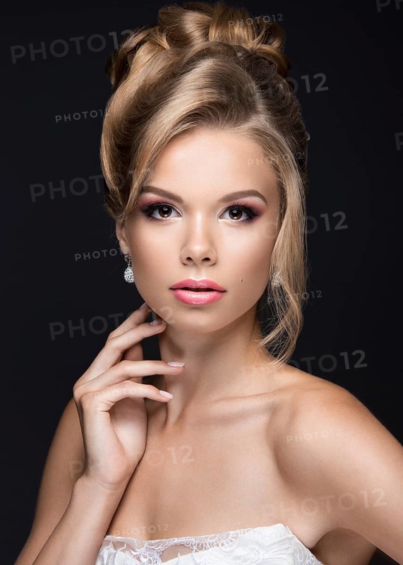 Portrait of a beautiful blond woman in the image of the bride. Picture taken in the studio on a black background. Beauty face and Hairstyle