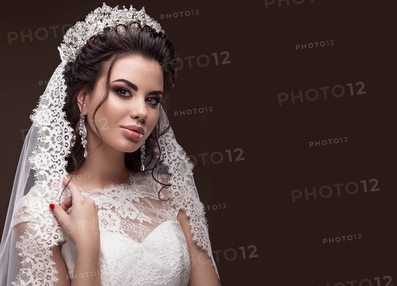 Beautiful brunette girl in the image of the Arab bride in a wedding dress and a crown on her head. Beauty face. Picture taken in the studio