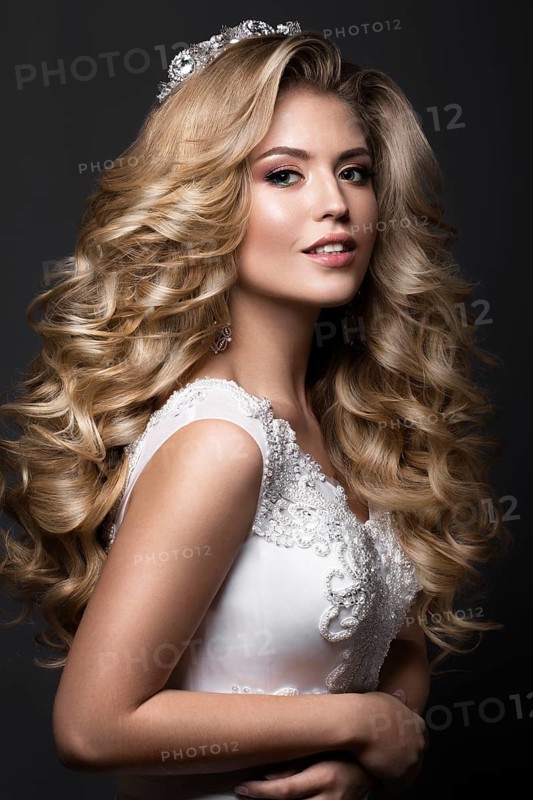 Beautiful blonde bride in wedding image with curls and crown. Beauty face. Picture taken in the studio