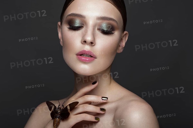 Portrait of beautiful girl with colorful make-up and cicada. Beauty face. Photo taken in the studio