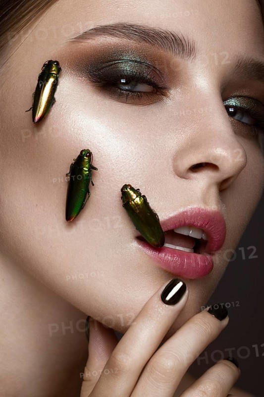 Portrait of beautiful girl with colorful make-up and cockroaches. Beauty face. Photo taken in the studio