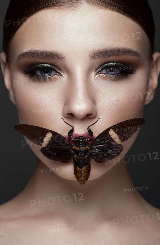 Portrait of beautiful girl with colorful make-up and cicada. Beauty face. Photo taken in the studio