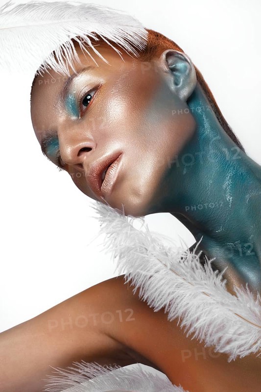 Portrait of a girl with gold and blue creative art make-up. Photo taken in the studio