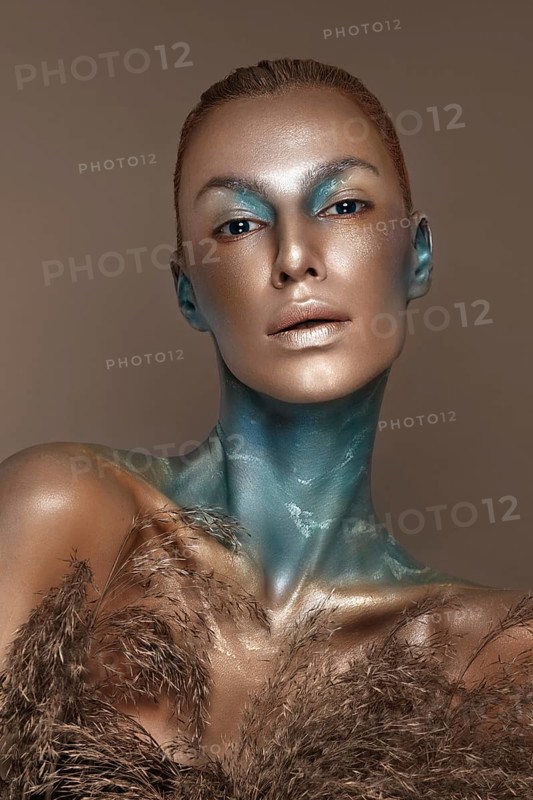 Portrait of a girl with gold and blue creative art make-up. Photo taken in the studio
