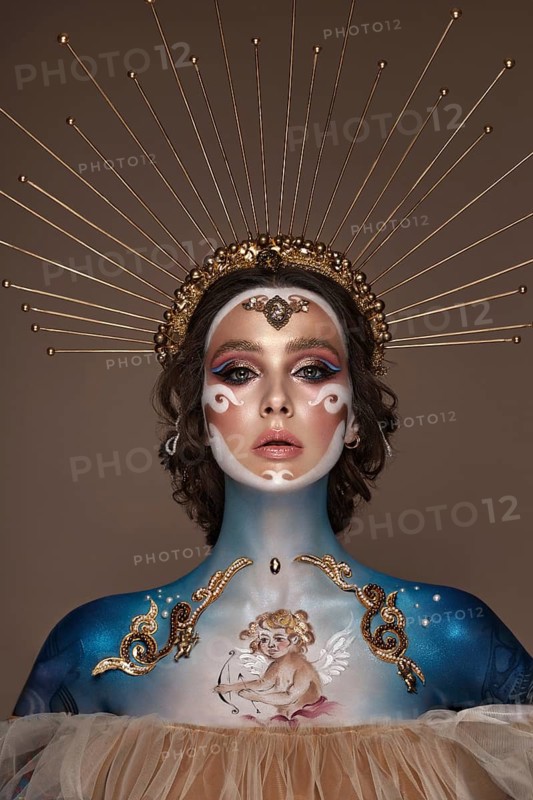 Portrait of a girl with gold and blue creative art make-up. Photo taken in the studio. Renaissance