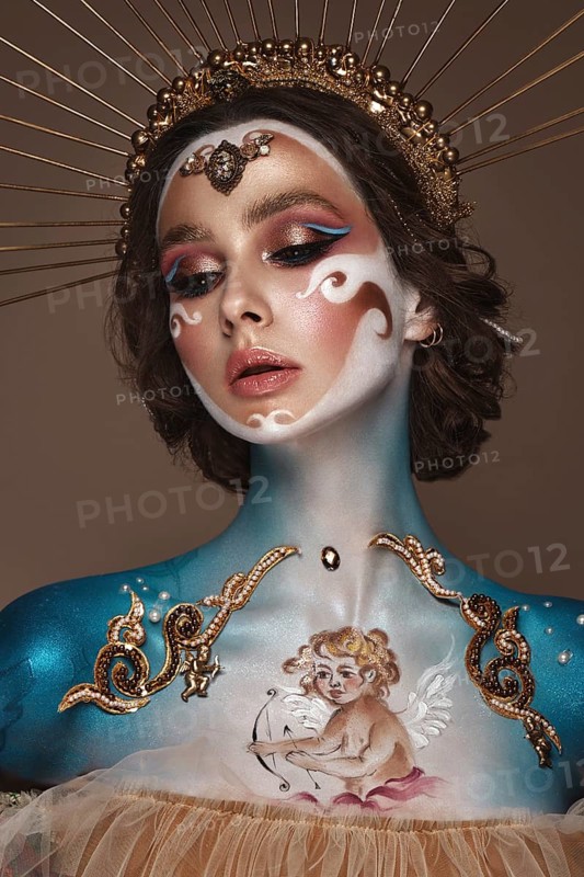 Portrait of a girl with gold and blue creative art make-up. Photo taken in the studio. Renaissance
