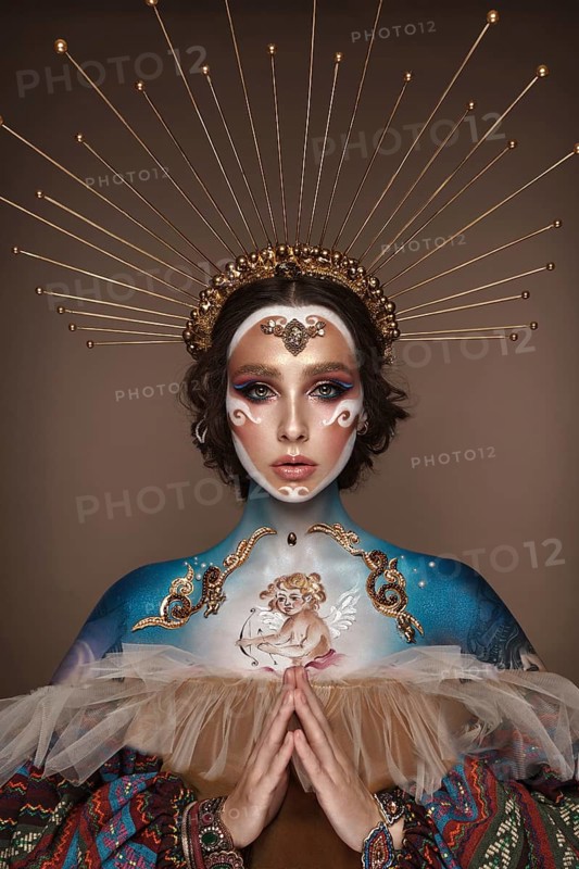 Portrait of a girl with gold and blue creative art make-up. Photo taken in the studio. Renaissance