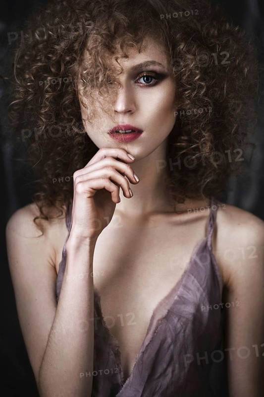 Beautiful girl with curly hair in lingerie with large flower. The beauty of the face. Photos shot in studio