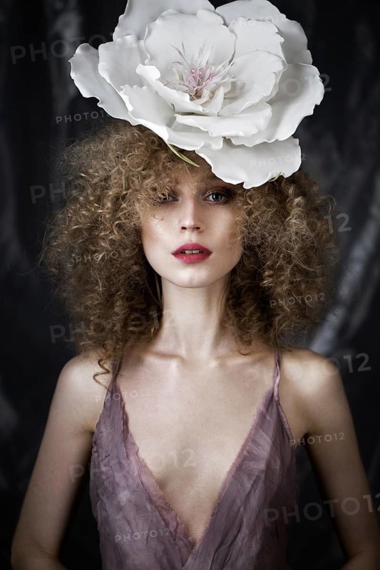 Beautiful girl with curly hair in lingerie with large flower. The beauty of the face. Photos shot in studio