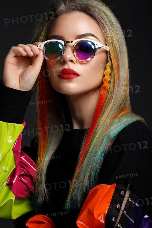 Beautiful girl with multi-colored hair and creative make-up and hairstyle. Beauty face. Photo taken in the studio