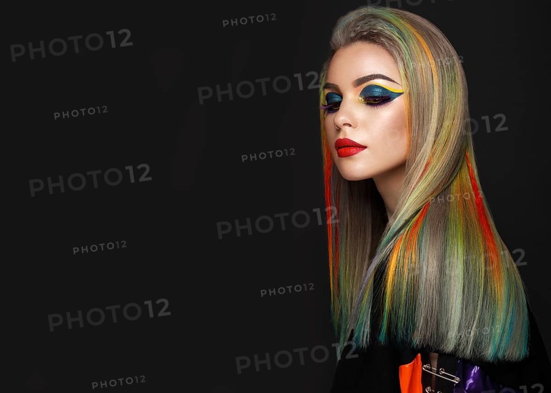 Beautiful girl with multi-colored hair and creative make-up and hairstyle. Beauty face. Photo taken in the studio