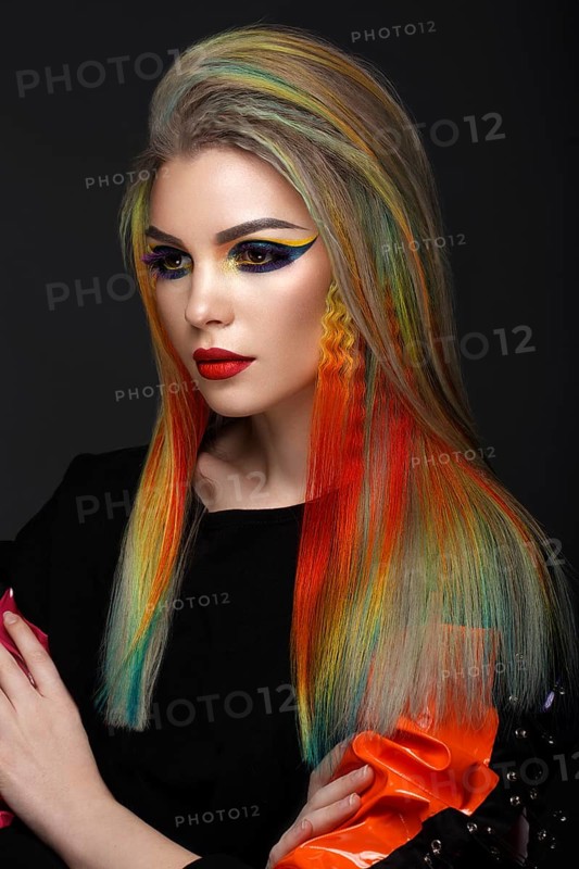 Beautiful girl with multi-colored hair and creative make-up and hairstyle. Beauty face. Photo taken in the studio