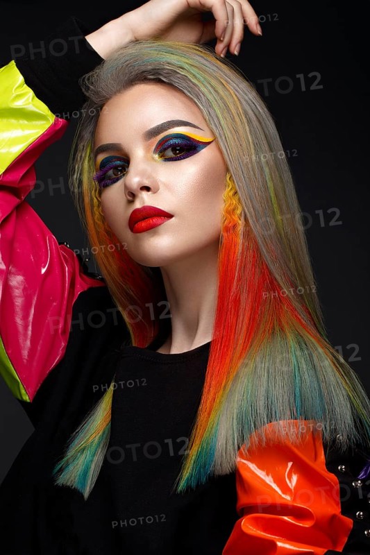 Beautiful girl with multi-colored hair and creative make-up and hairstyle. Beauty face. Photo taken in the studio