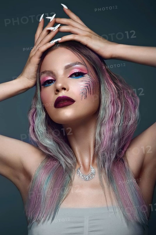 Beautiful girl with multi-colored hair and creative make up and hairstyle. Beauty face. Photo taken in the studio