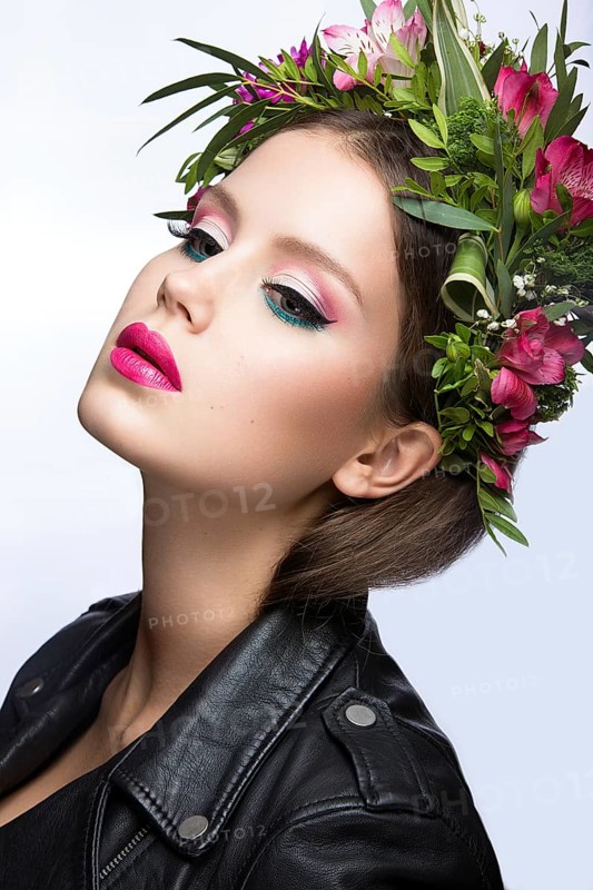 Portrait of a beautiful woman in the image of the bride with flowers in her hair. Picture taken in the studio on a black background