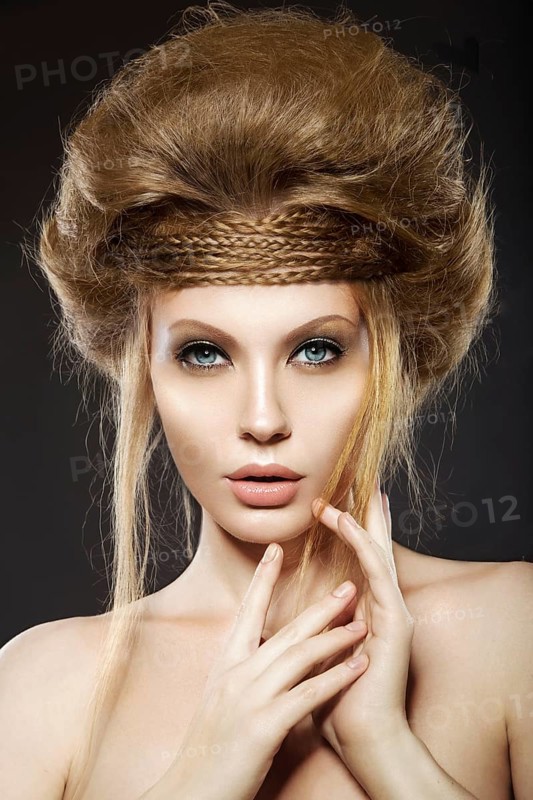 Beautiful red-haired girl with perfect skin and an unusual hairstyle. Picture taken in the studio on a black background