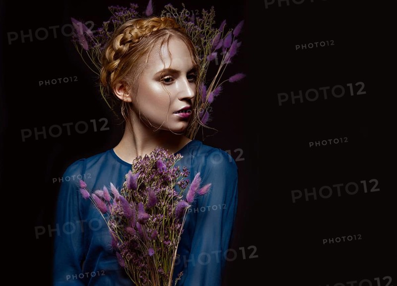 Beautiful girl with a gentle make-up and hairstyle in the form of braids