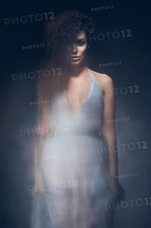 Beautiful girl in a light blue dress and long hair in a fashionable image. Beauty fashion style. Picture taken in the studio with mixed light