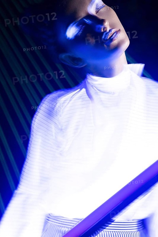 Fashion model beautiful girl in fashionable clothes in ultraviolet light