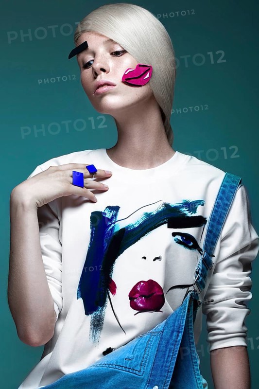 Fashionable girl with natural make-up in clothes with a picture in the style of pop art