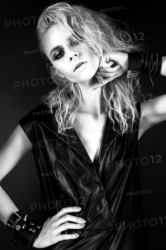 Daring girl model in black leather dress in the style of rock