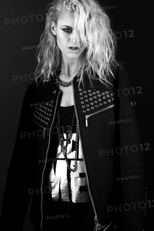 Daring girl model in black leather dress in the style of rock