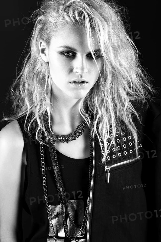 Daring girl model in black leather dress in the style of rock