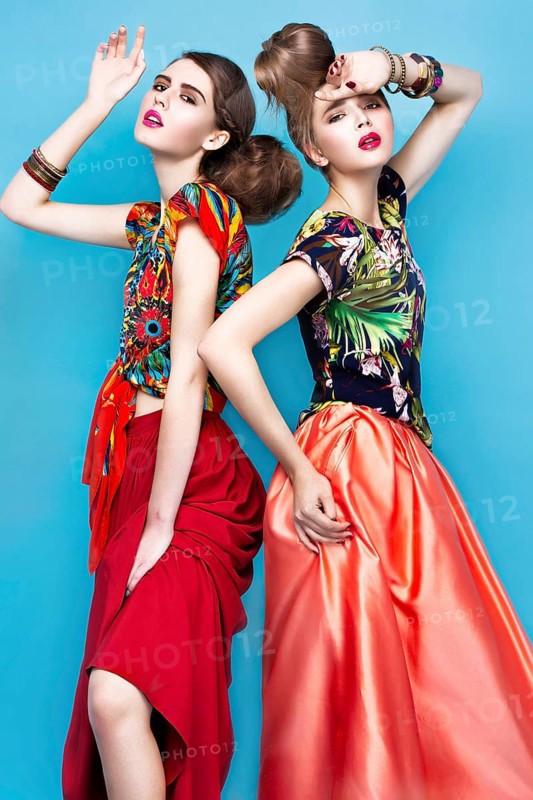 Beautiful fashionable women an unusual hairstyle in bright clothes and colorful accessories. Cuban style. Picture taken in the studio on a bright background