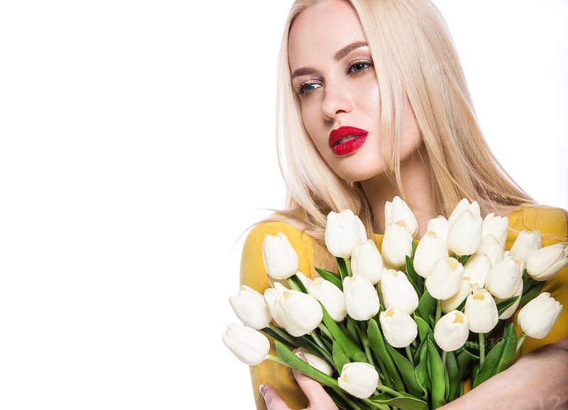 Portrait of beautiful fashion model with bouquet lily in hands