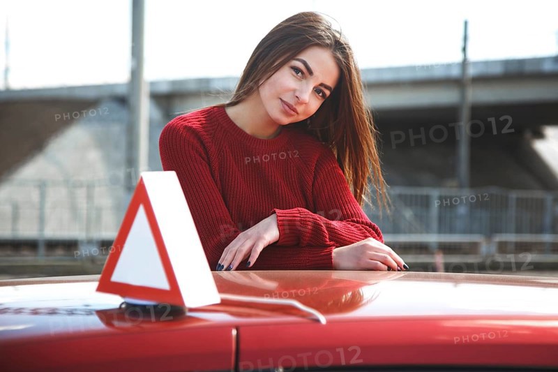 Young beautiful happy woman posing near training car
