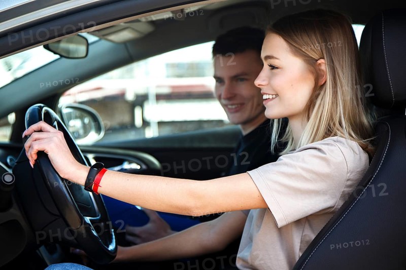 The driver is an auto school instructor and a female student on an examination car. Lesson at the circuit