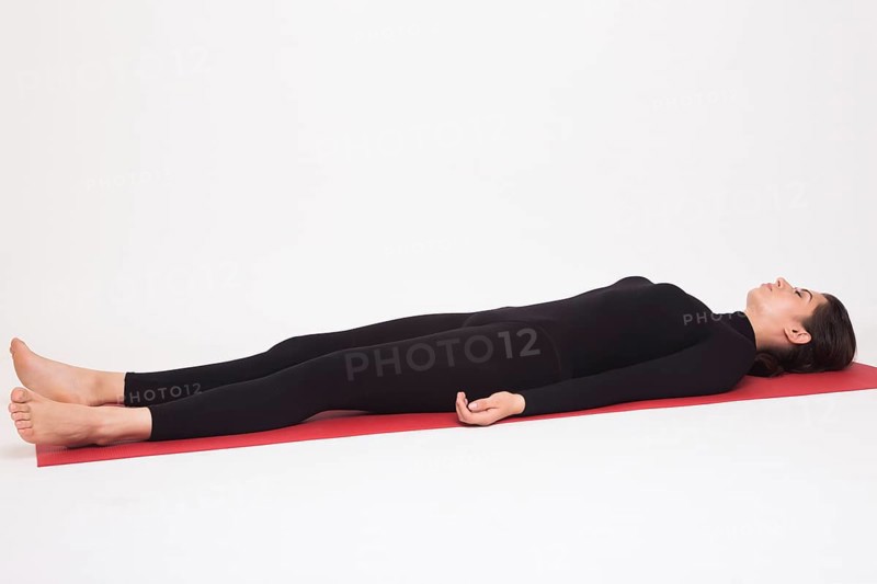 Beautiful athletic girl in black suit doing yoga asanas. Isolated on white background
