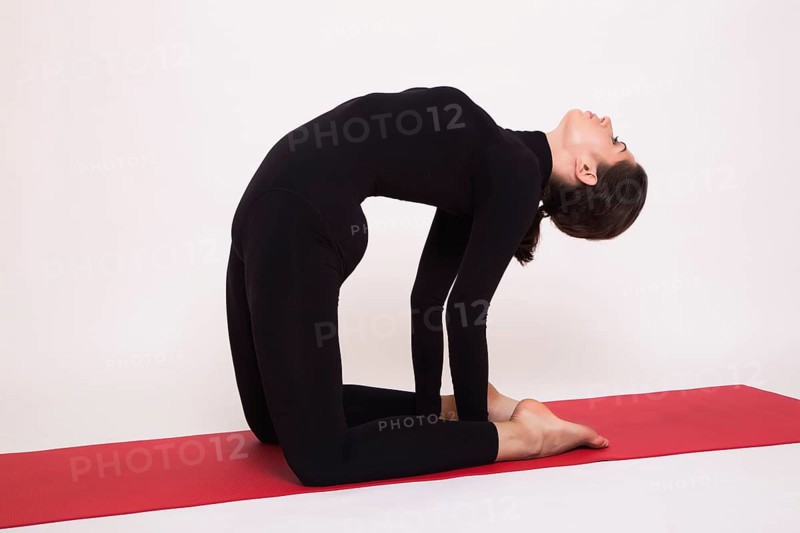 Beautiful athletic girl in black suit doing yoga asanas. Isolated on white background