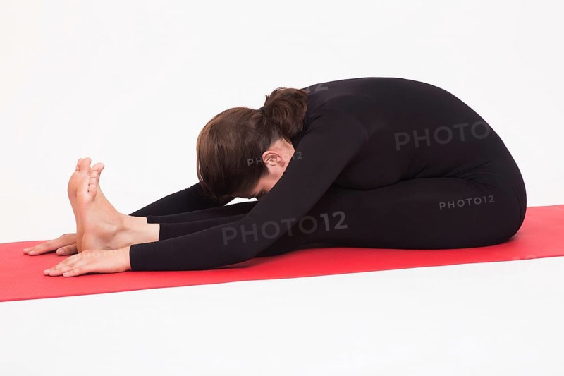 Beautiful athletic girl in black suit doing yoga asanas. Isolated on white background