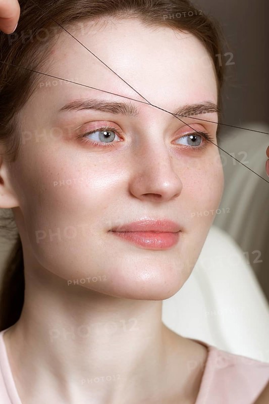 Permanent microblasting tattooing freckles to a woman in a beauty salon