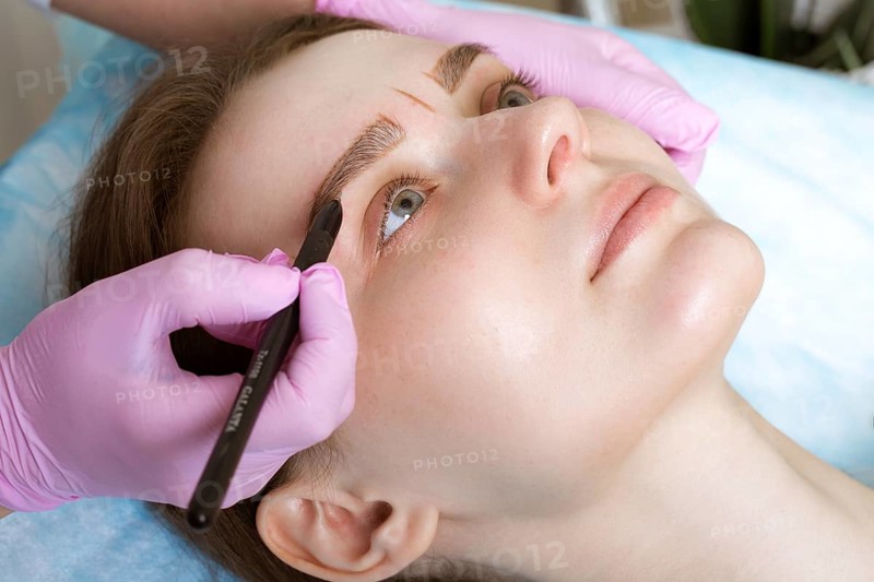 Permanent microblasting tattooing freckles to a woman in a beauty salon