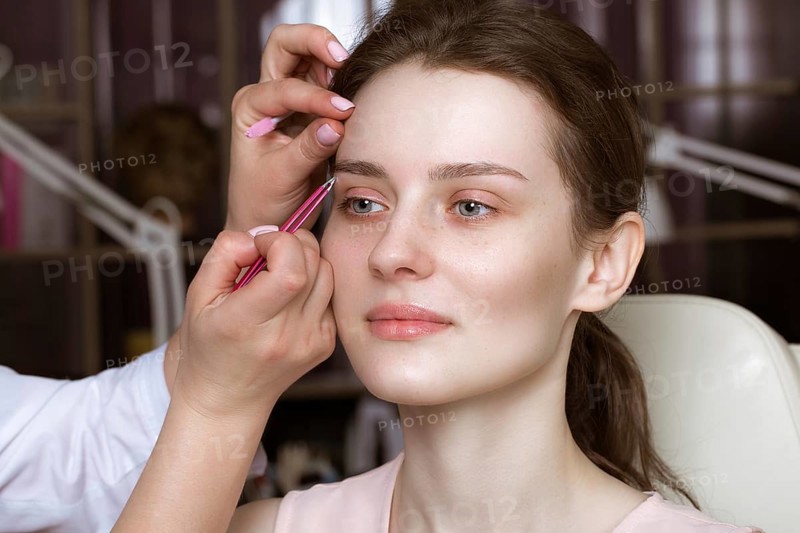 Permanent microblasting tattooing freckles to a woman in a beauty salon