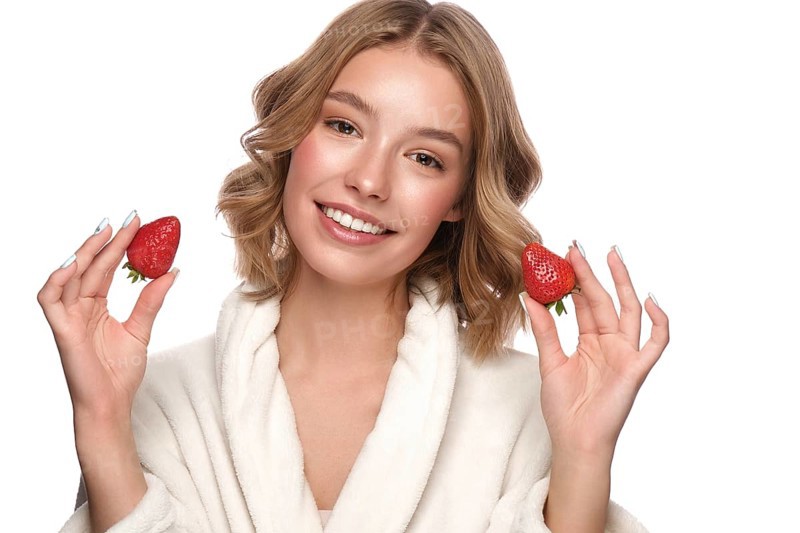 Beautiful tender young girl in a white coat with clean fresh skin posing in front of the camera. Beauty face. Skin care. Photo taken in studio on a white isolate background