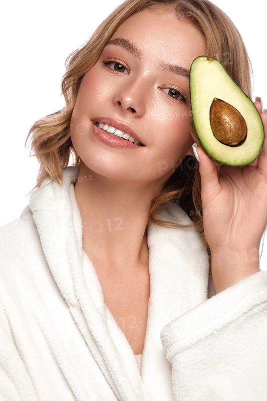 Beautiful tender young girl in a white coat with clean fresh skin posing in front of the camera. Beauty face. Skin care. Photo taken in studio on a white isolate background