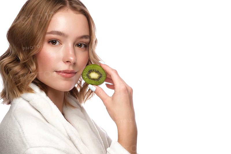 Beautiful tender young girl in a white coat with clean fresh skin posing in front of the camera. Beauty face. Skin care. Photo taken in studio on a white isolate background