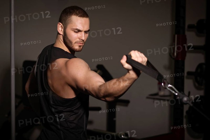 Sporty sexy men with great abdominal muscles in black sportswear working out in the gym