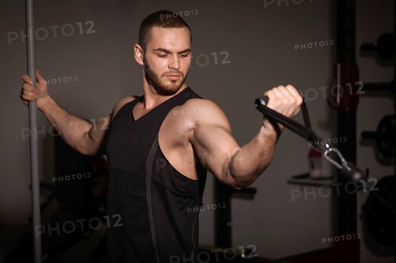Sporty sexy men with great abdominal muscles in black sportswear working out in the gym
