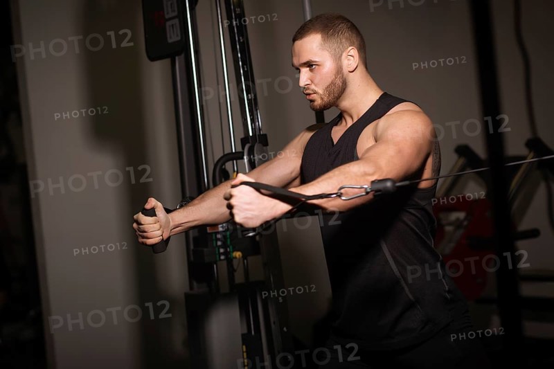 Sporty sexy men with great abdominal muscles in black sportswear working out in the gym